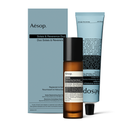 Eine Pumpflasche Solais Replenishing Hand Serum und eine Tube Reverence Aromatique Hand Balm zusammen in einem Karton 
