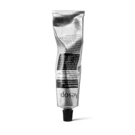 Eine zerknitterte silberne Tube Aesop Resurrection Aromatique Hand Balm, die auf ihrem schwarzen Deckel vor weißem Hintergrund steht.